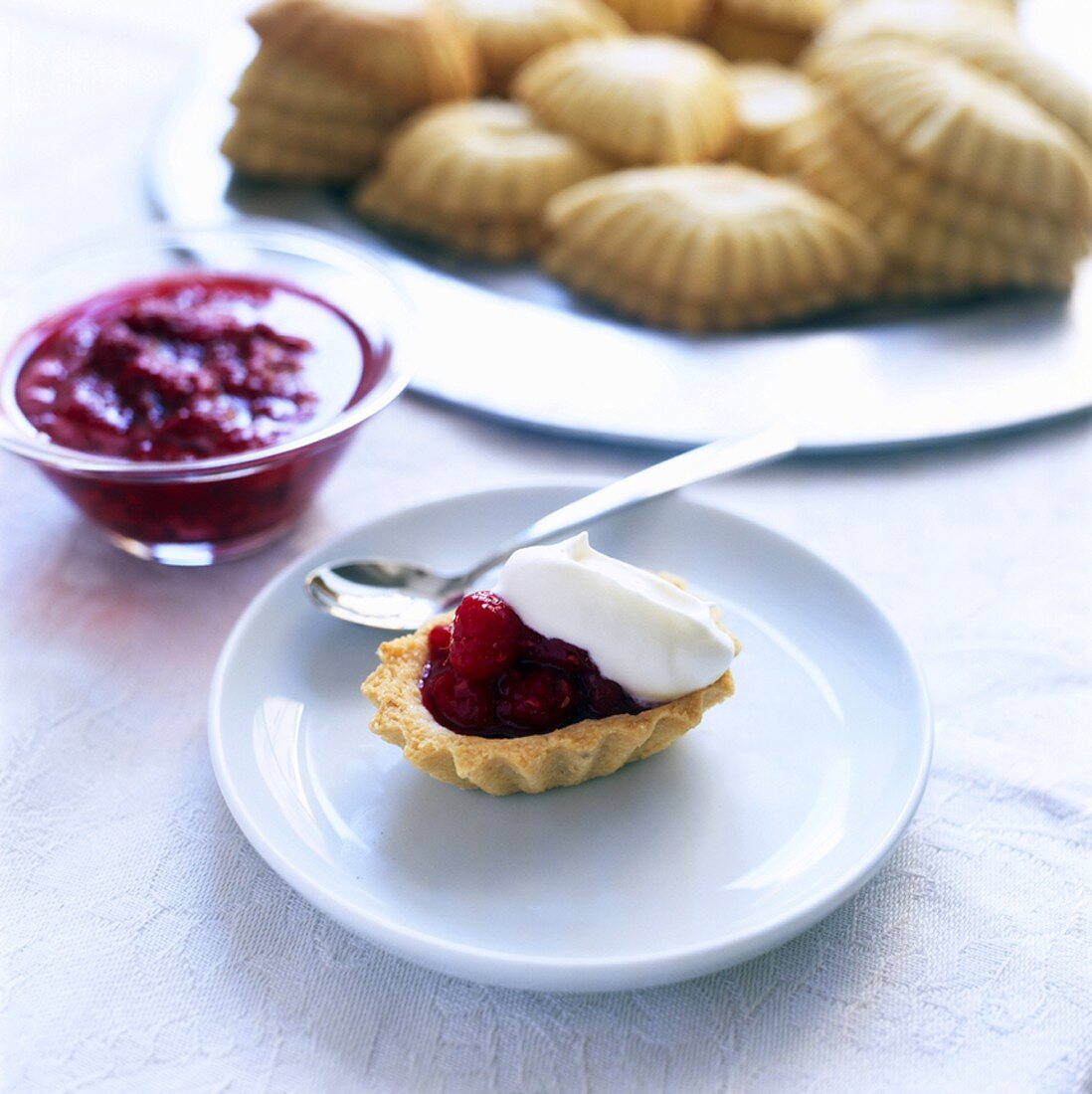 Gebäck mit Himbeermarmelade und Sahne