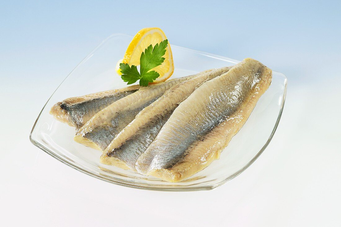 Matjes herring fillets on glass plate