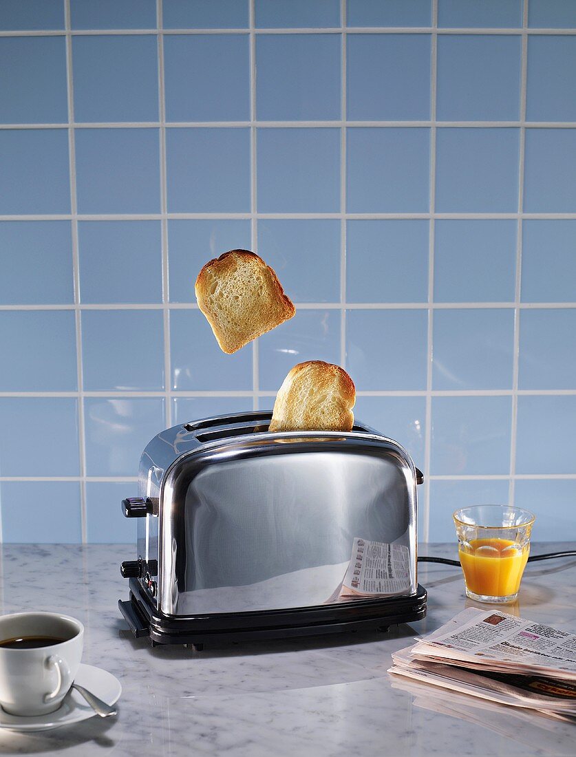 Toaster, coffee, orange juice and newspaper