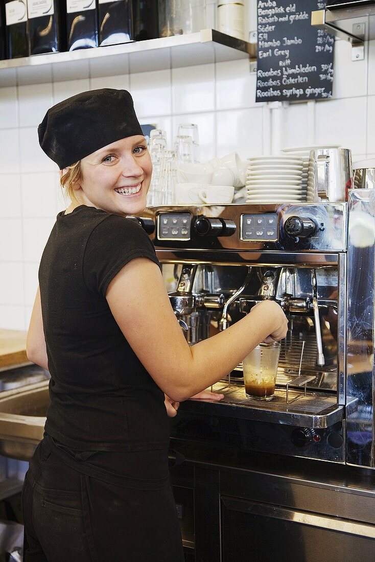 Angestellte im Café bei der Espressomaschine