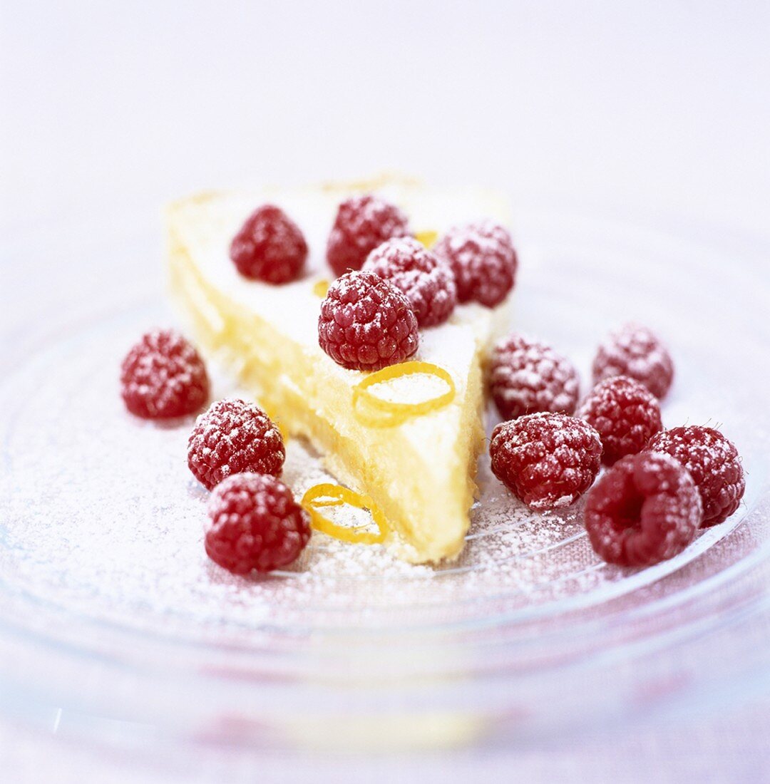 Stück Zitronenpie mit Himbeeren und Puderzucker