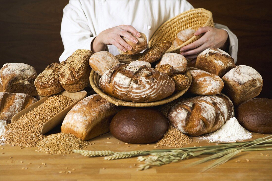 Baker with various types of bread and bread rolls