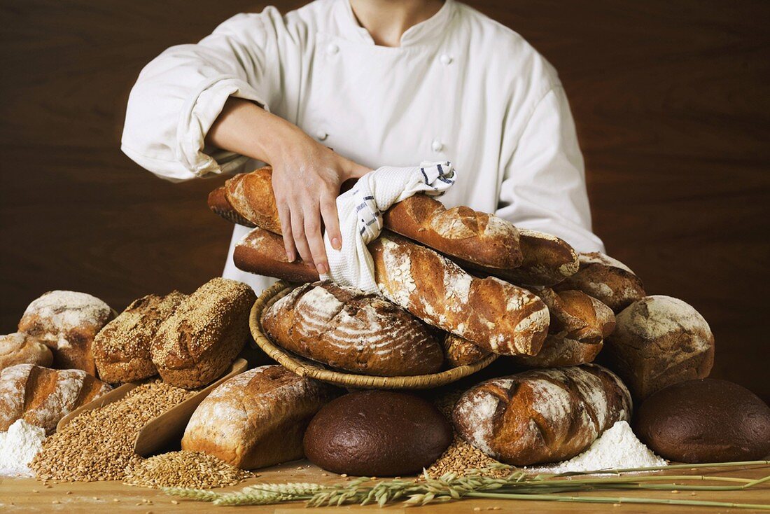 Baker with various loaves of bread