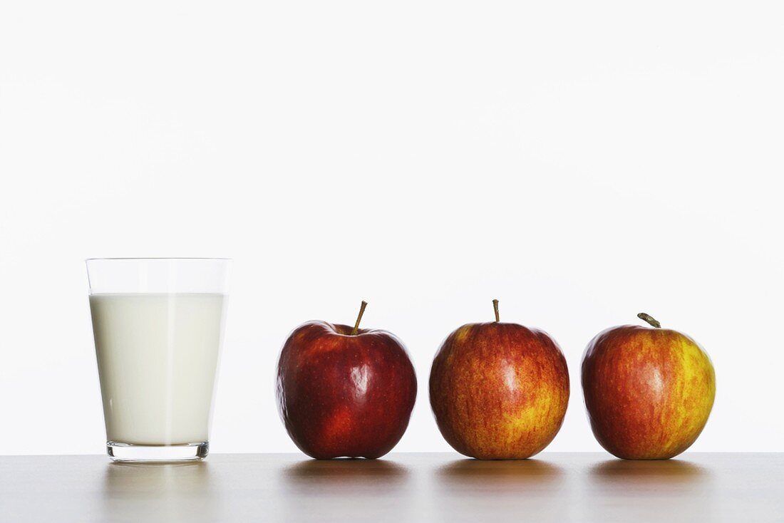 Drei Äpfel und Glas Milch