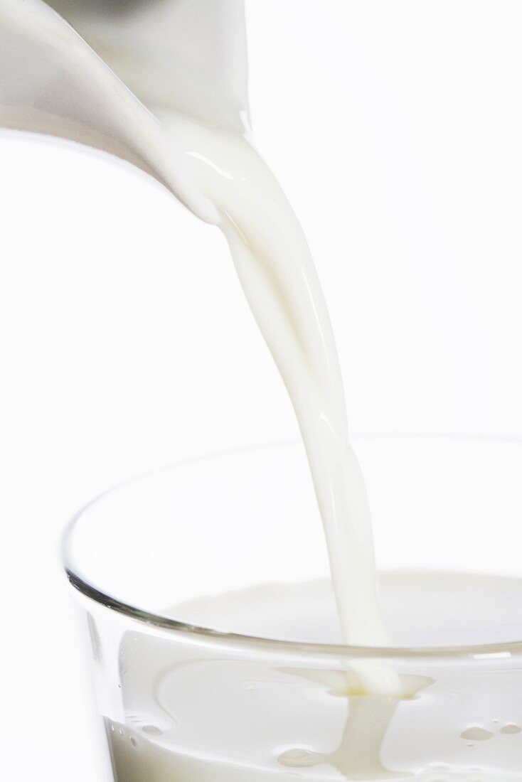 Pouring milk into glass (close-up)