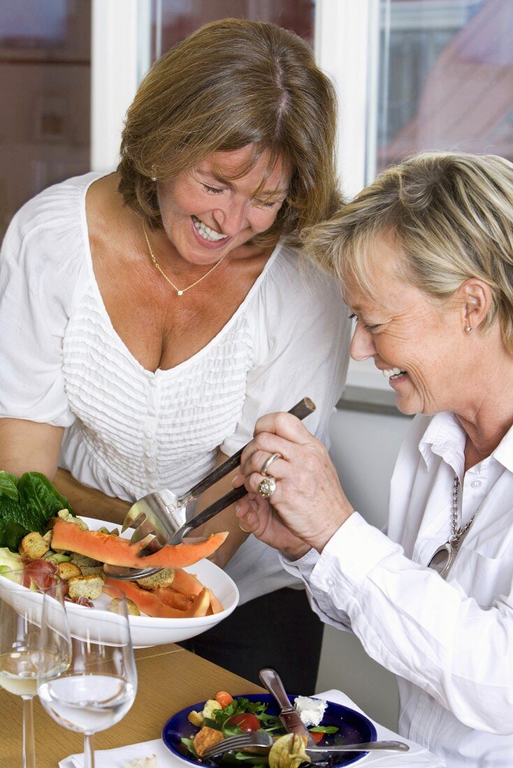Two cheerful women eating a meal