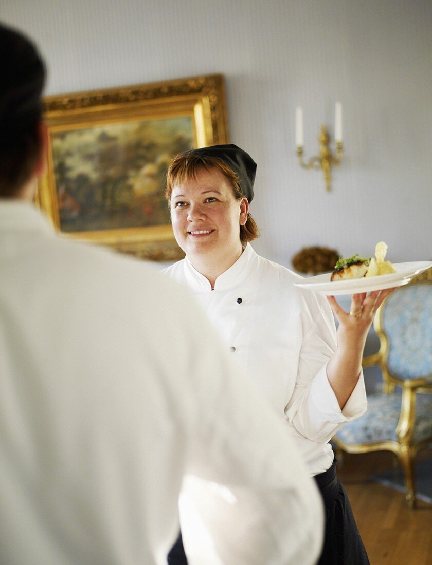 Köchin serviert Essen in schwedischem Schloss