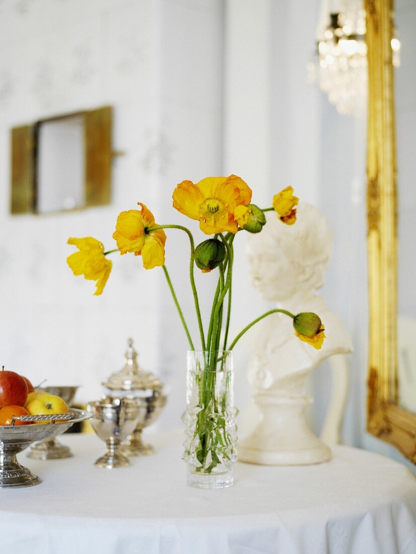 Vase of flowers and porcelain figure on table