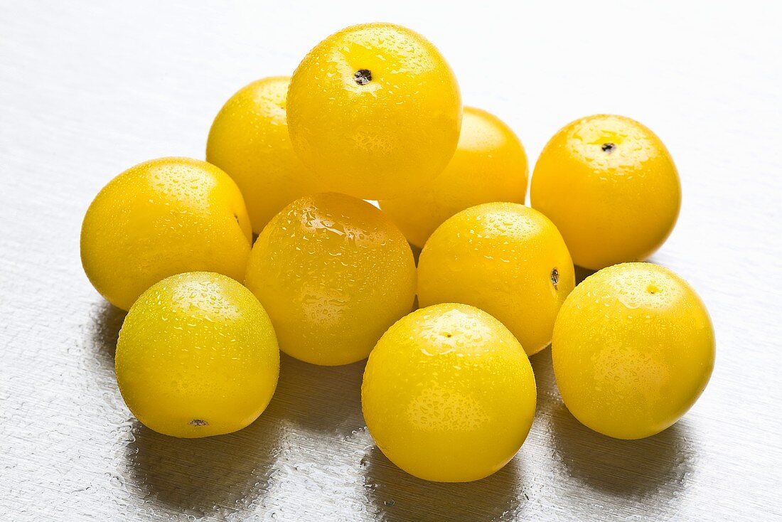 Several yellow plums with drops of water