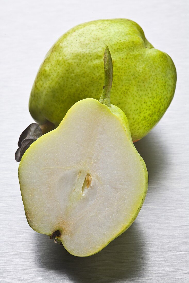 Whole green pear and half a pear