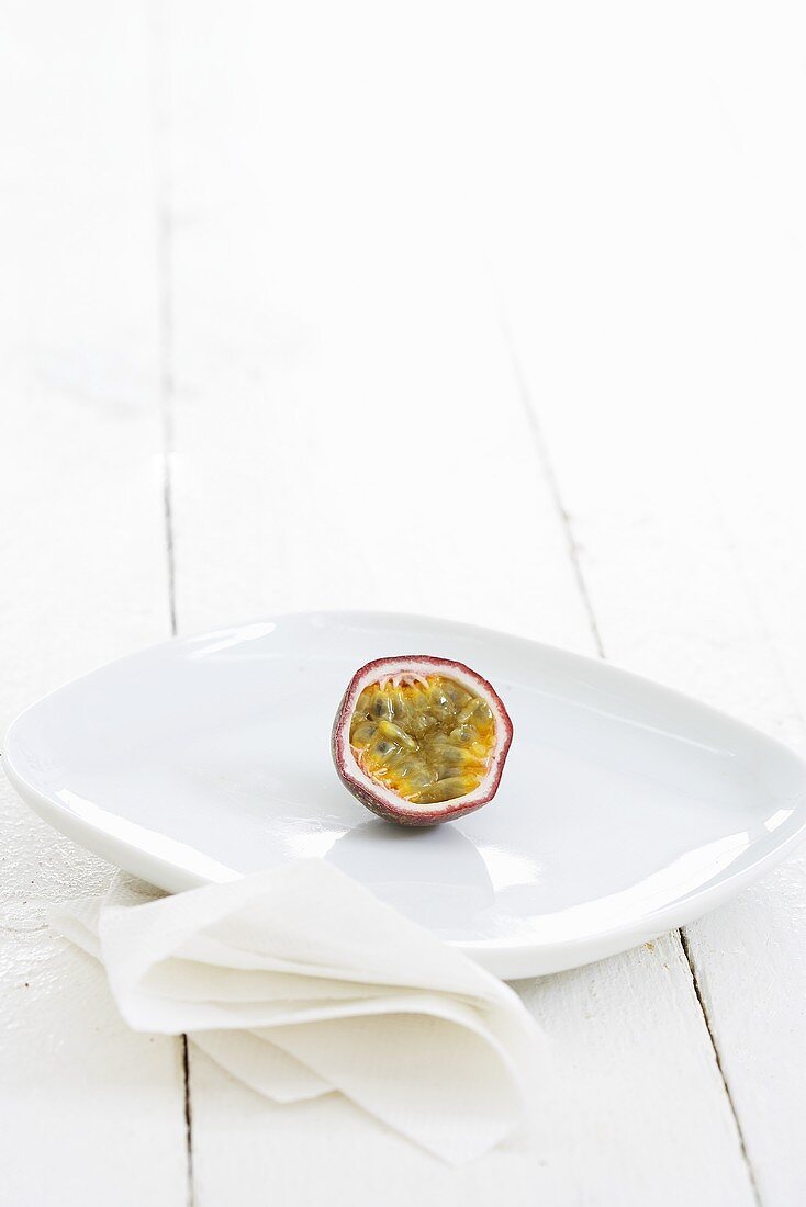 Half a purple passion fruit on plate