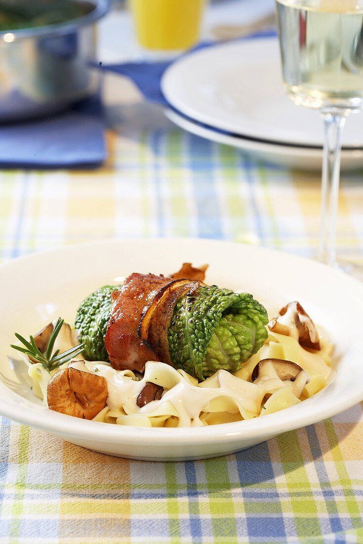 Stuffed savoy cabbage leaf on ribbon pasta with mushrooms