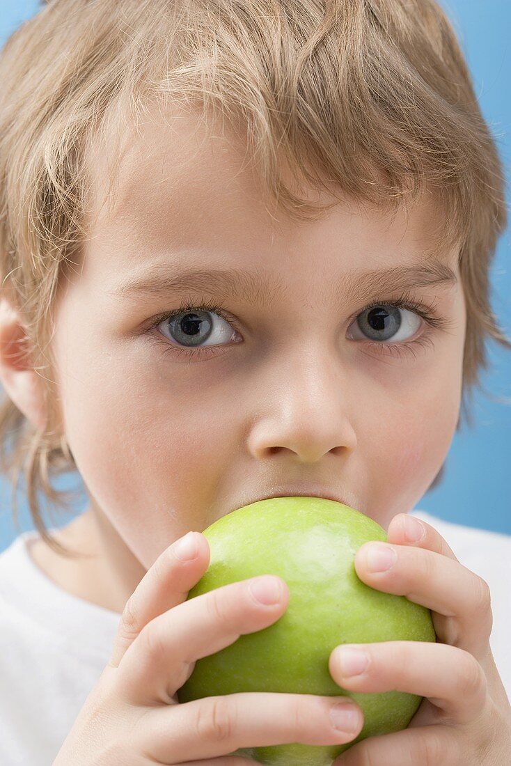 Kleiner Junge beisst in Apfel