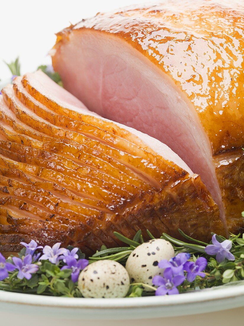 Glazed roast ham surrounded by herbs for Easter (close-up)
