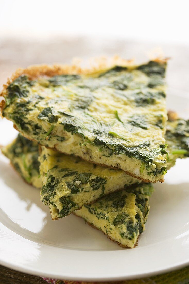 Slices of Chopped Spinach Frittata; Stacked on White Plate