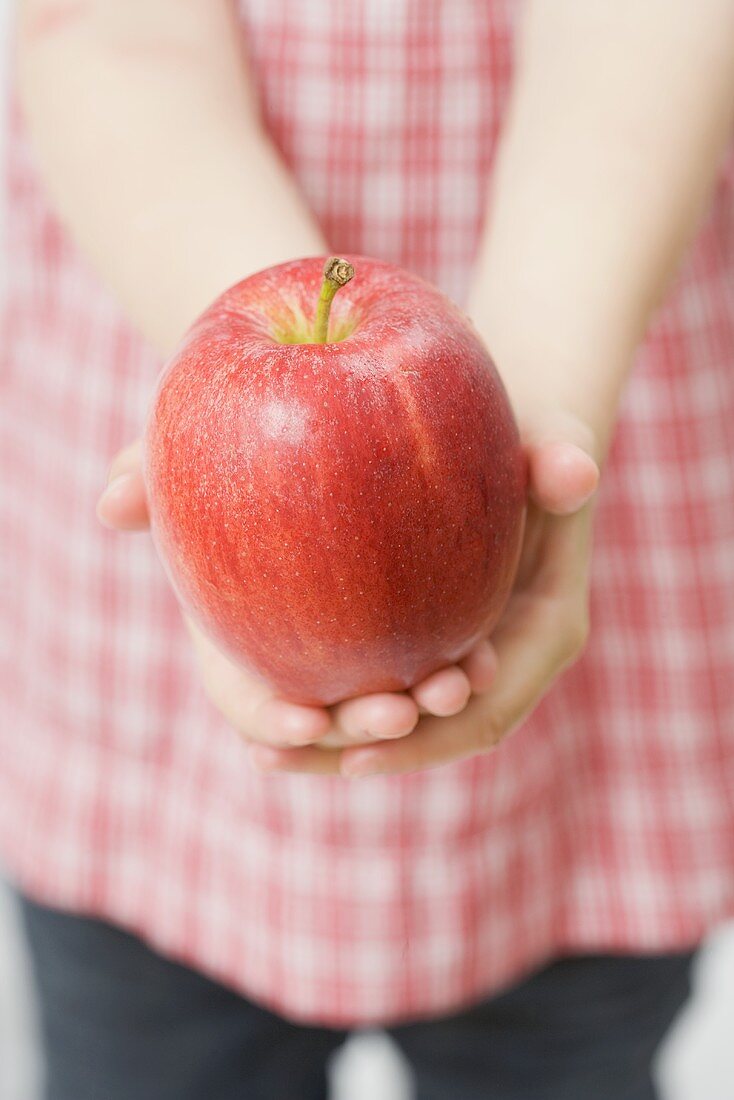 Kind hält roten Apfel