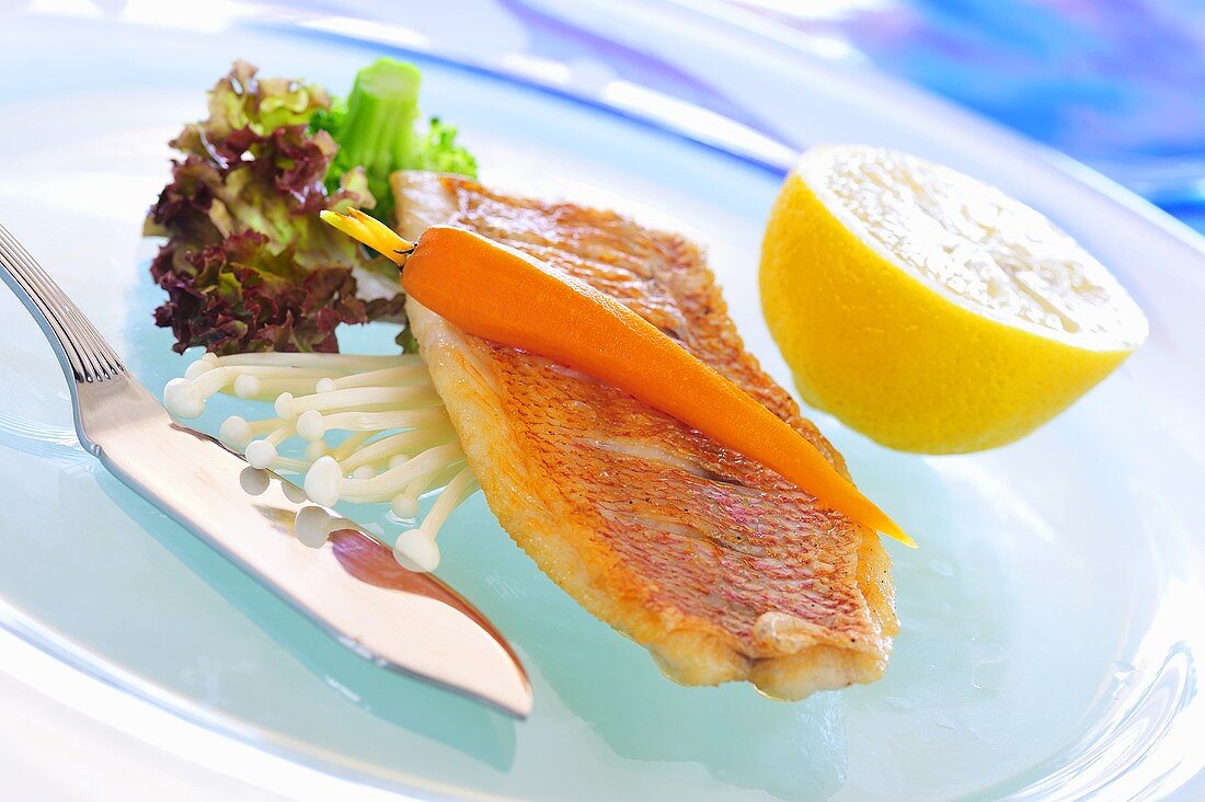 Fried red snapper with carrot on enokitake mushrooms