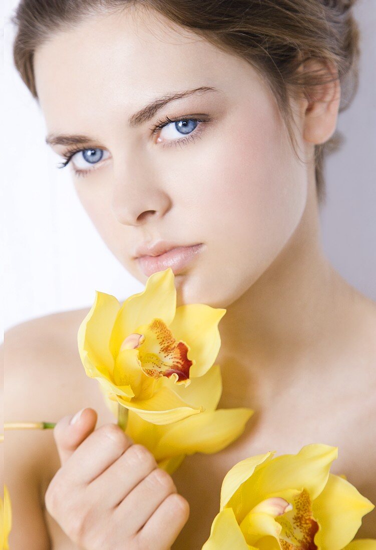 Young woman with yellow orchids