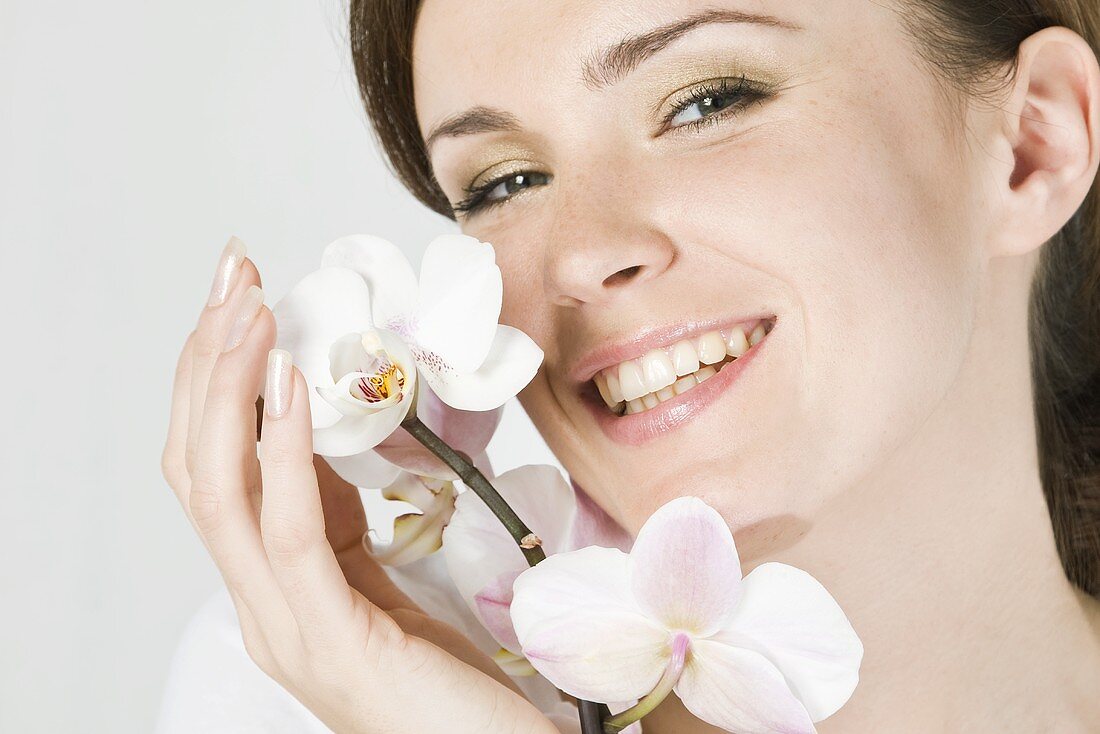 Smiling woman with white orchid