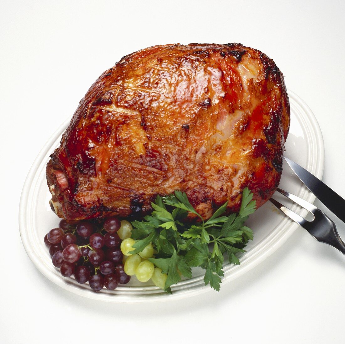 Apricot Glazed Ham on Platter with Carving Utensils 