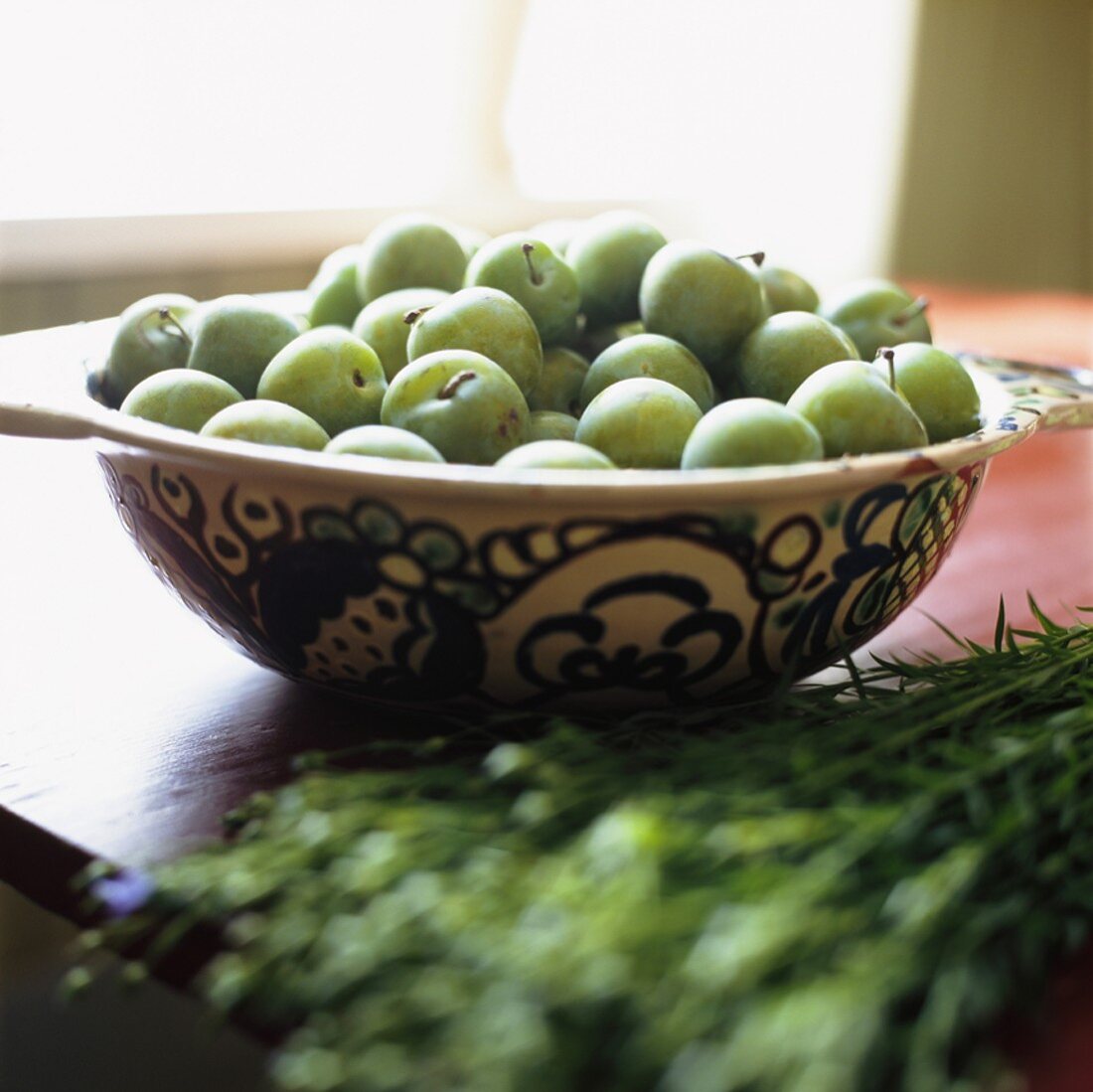 Green apples in ceramic bowl