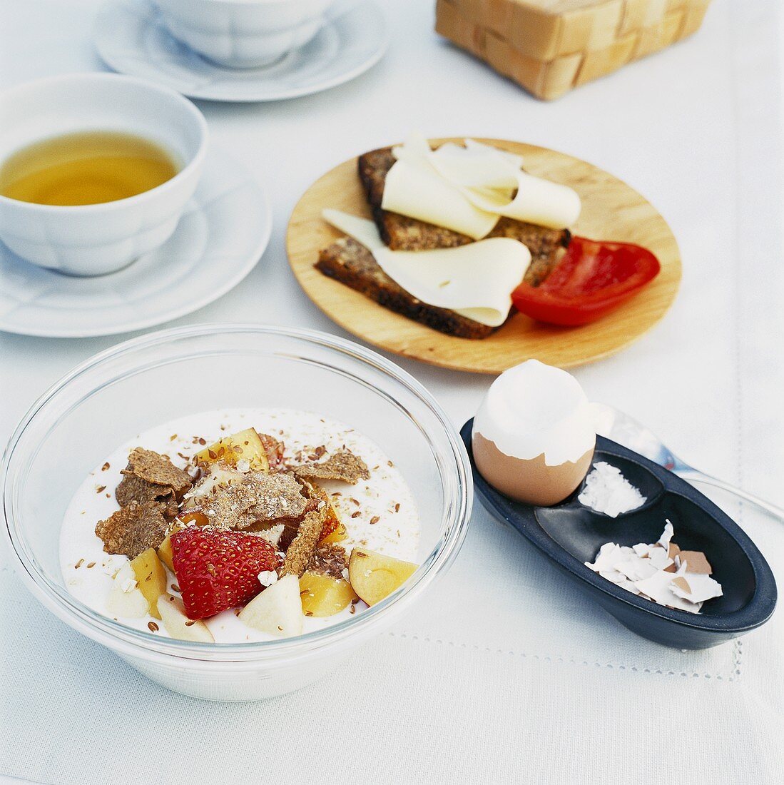 Frühstück mit Müsli, Tee, Ei und Käsebroten