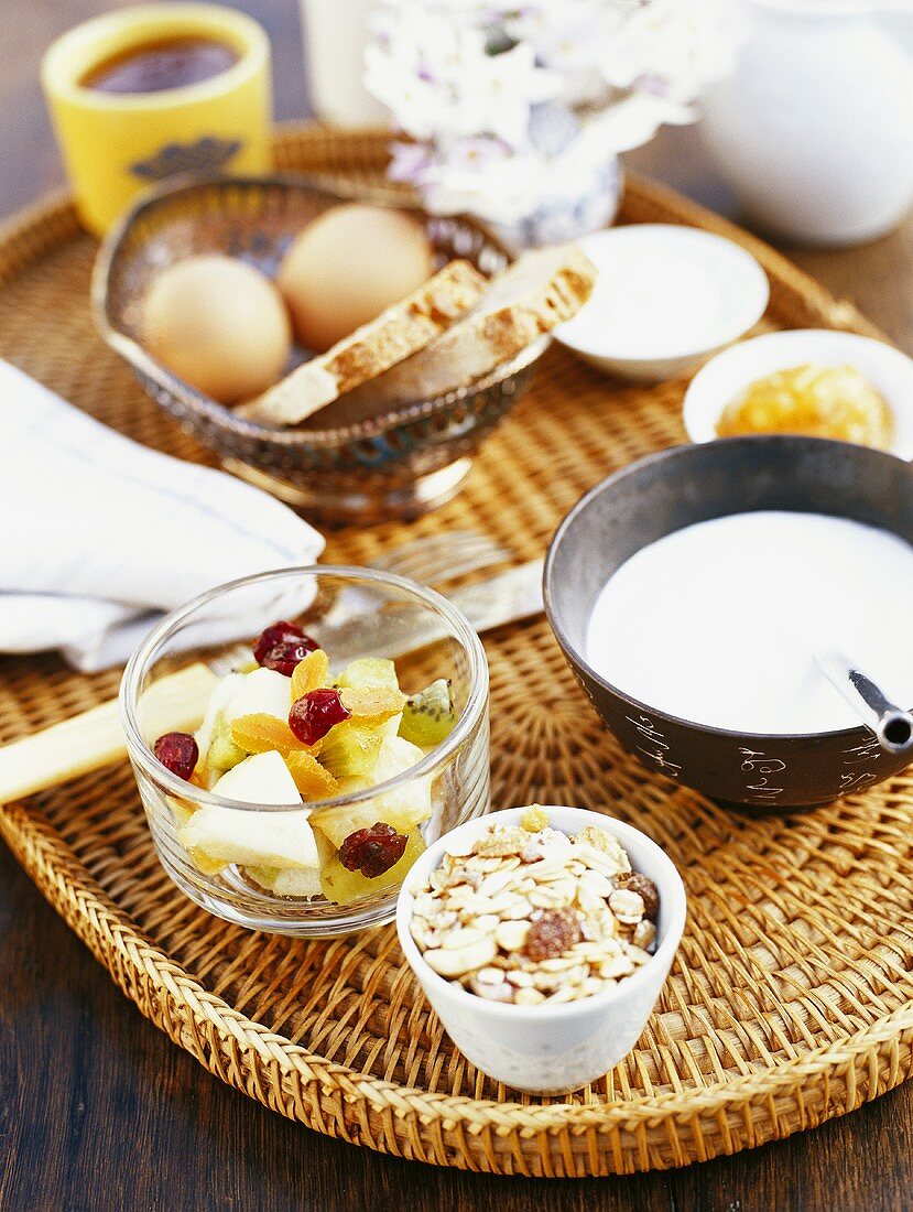 Frühstückstablett mit Müslizutaten, Eiern, Brot, Marmelade
