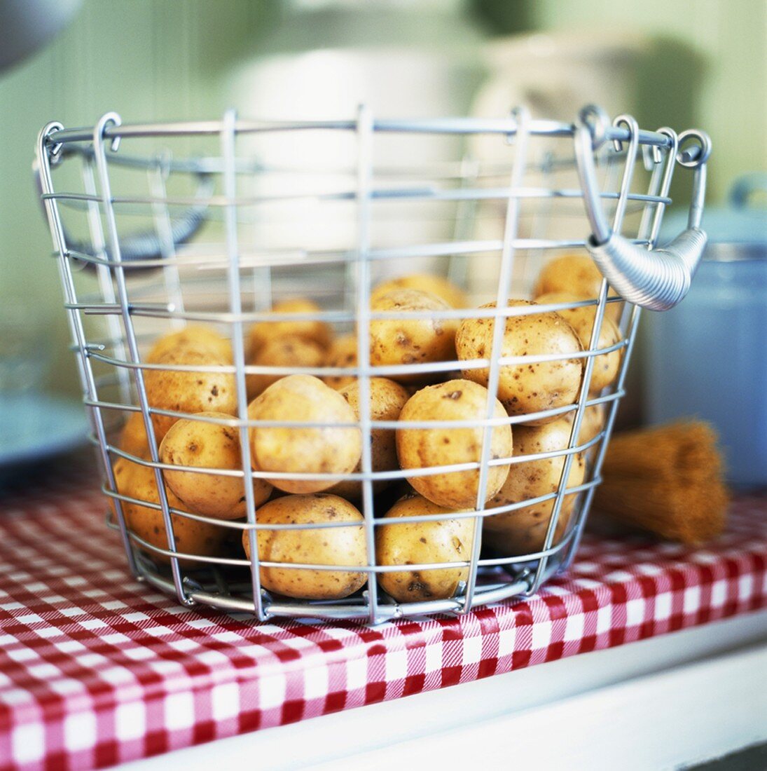 Potatoes in wire basket on kitchen table
