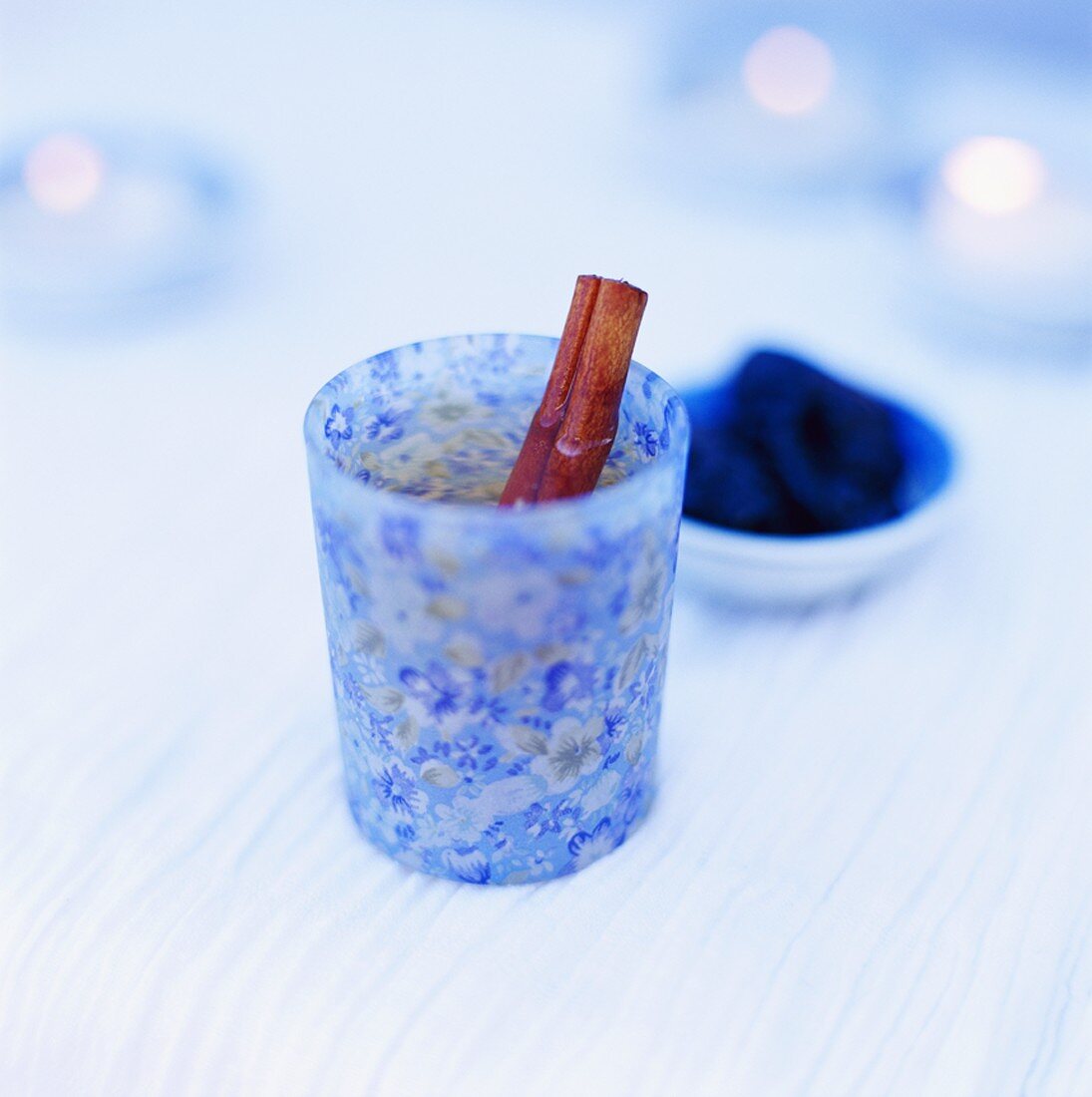 Tee mit Zimtstange in blauem Glas