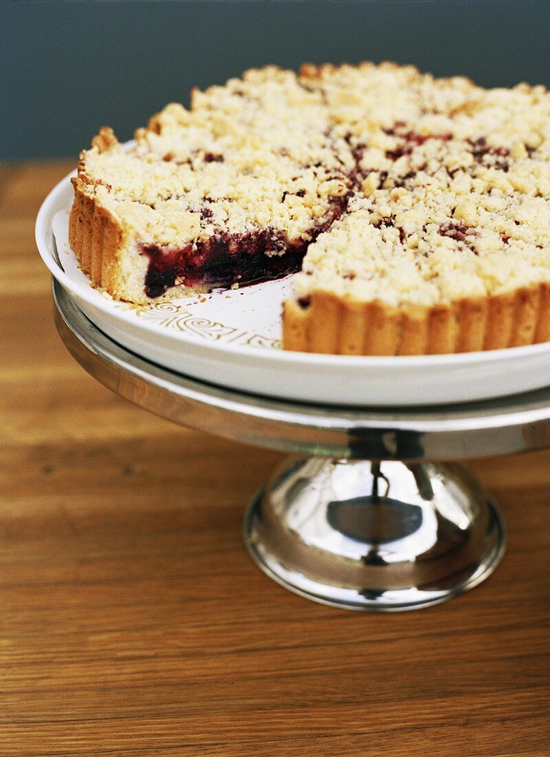Berry crumble tart on cake stand
