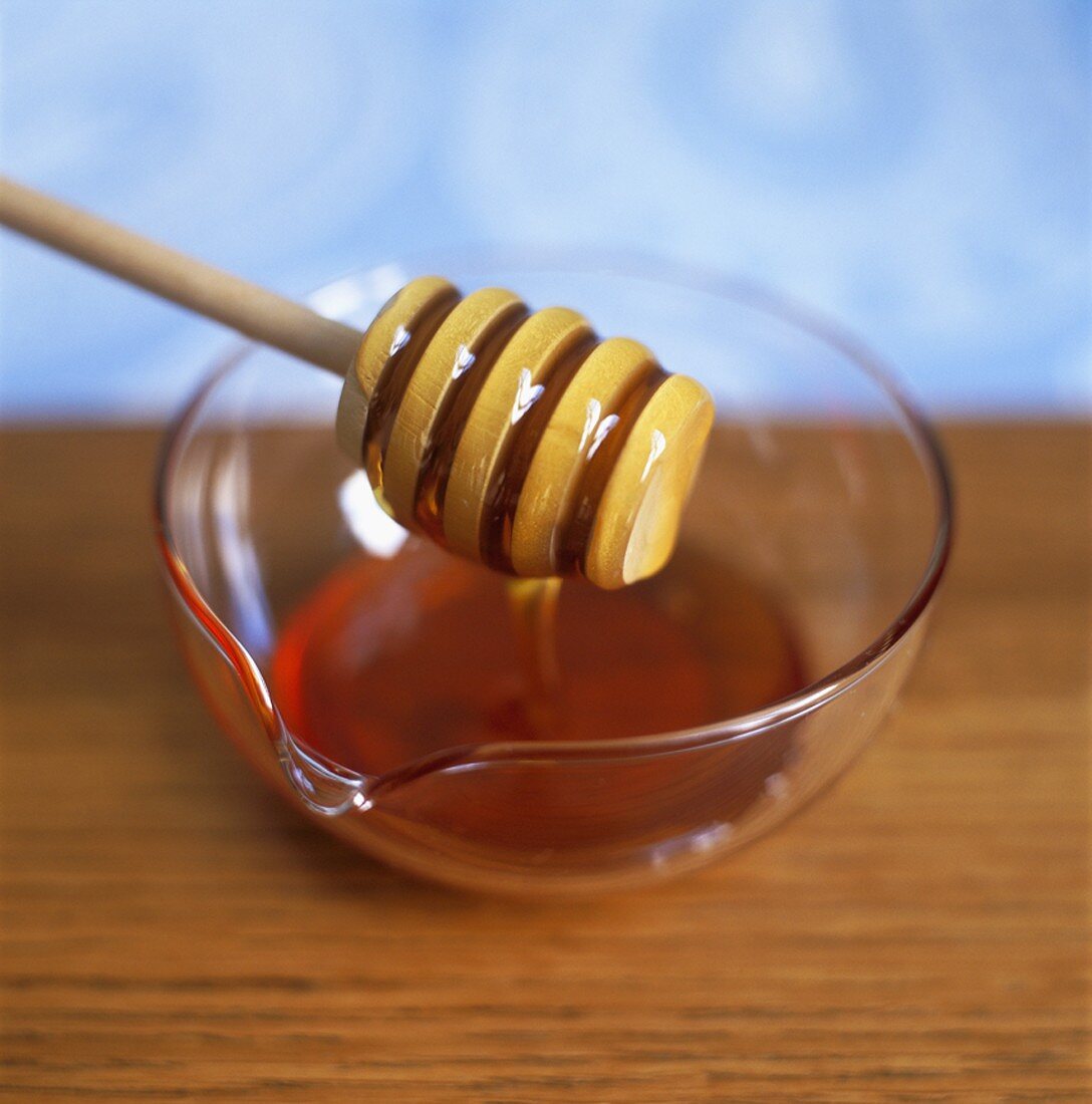 Honig in Glasschale mit Honigheber
