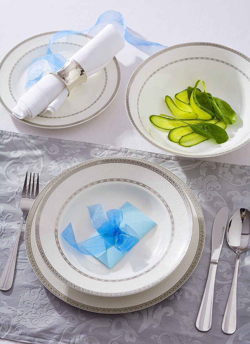 Place-setting with pickled gherkins in a dish