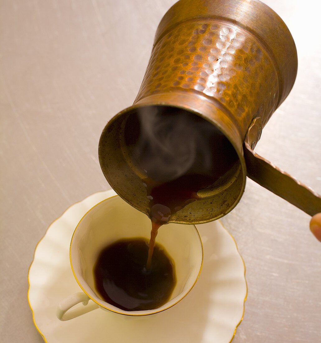 Türkischen Kaffee in eine Tasse gießen