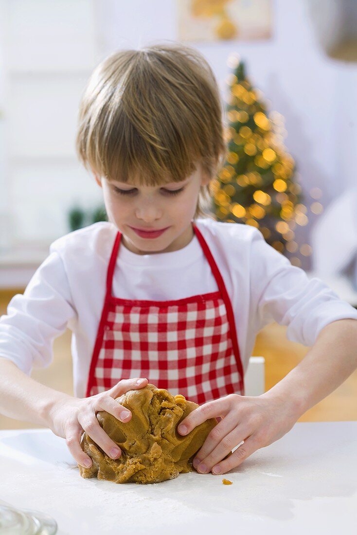 Little boy kneading dough for Christmas biscuits