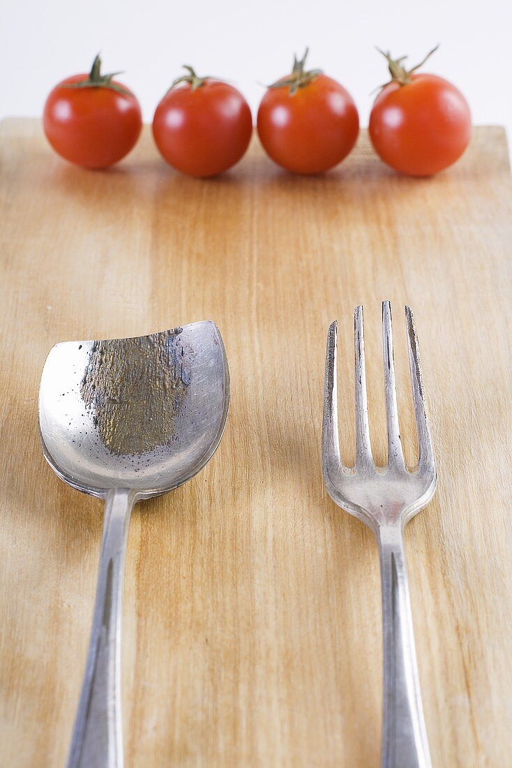 Old cutlery and four cherry tomatoes