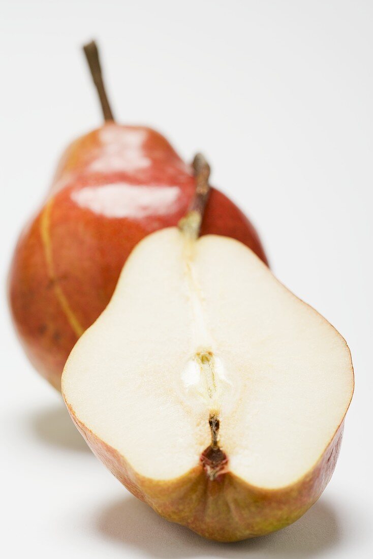 Whole red Williams pear and half a pear
