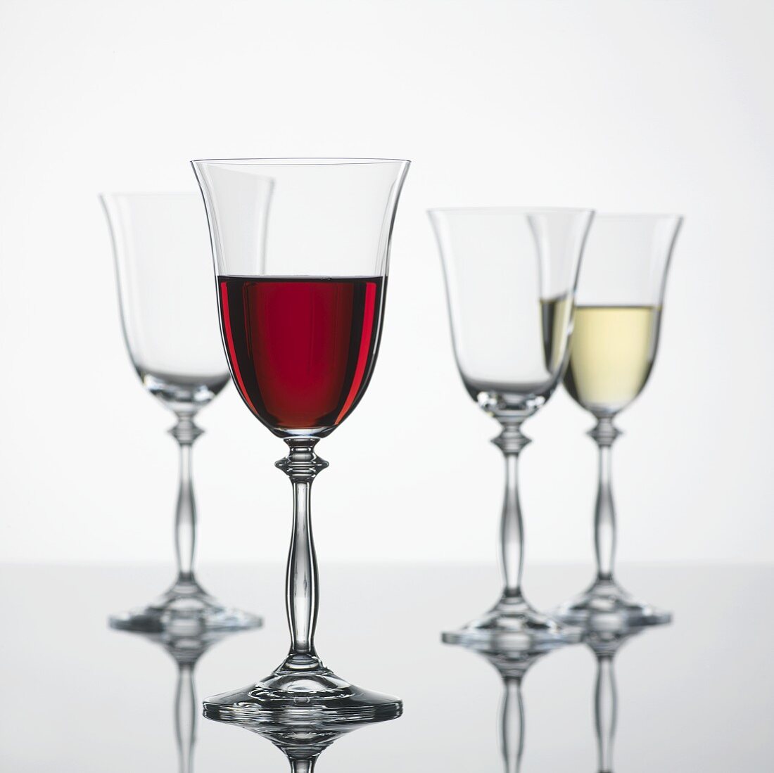 Glass of red wine, glass of white wine & empty wine glasses