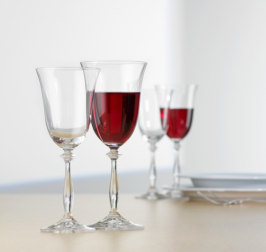Glasses of red wine on table