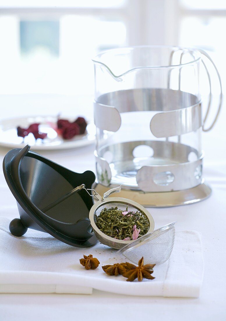 Teesieb mit Tee und Teekanne