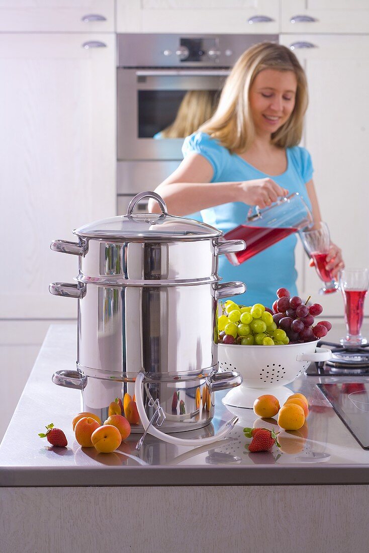 Juicer, woman in background pouring juice into glass