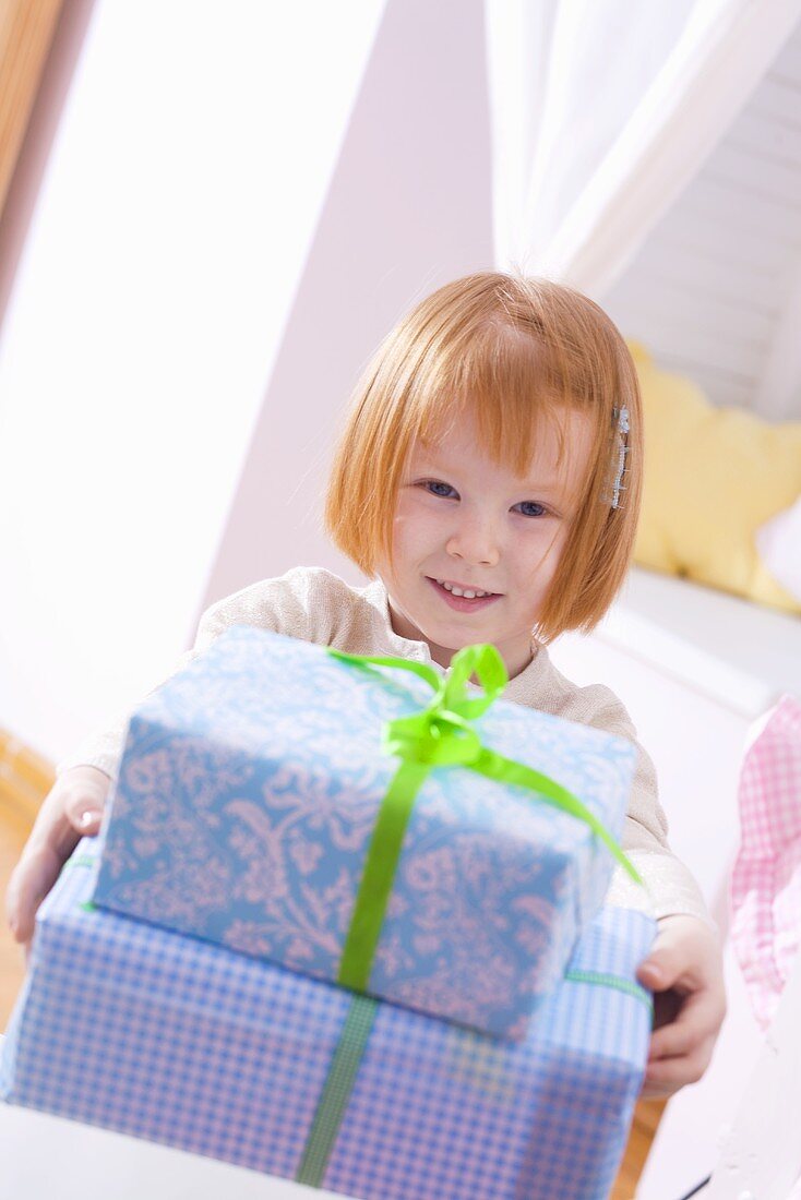 Kleines Mädchen mit Weihnachtspaketen