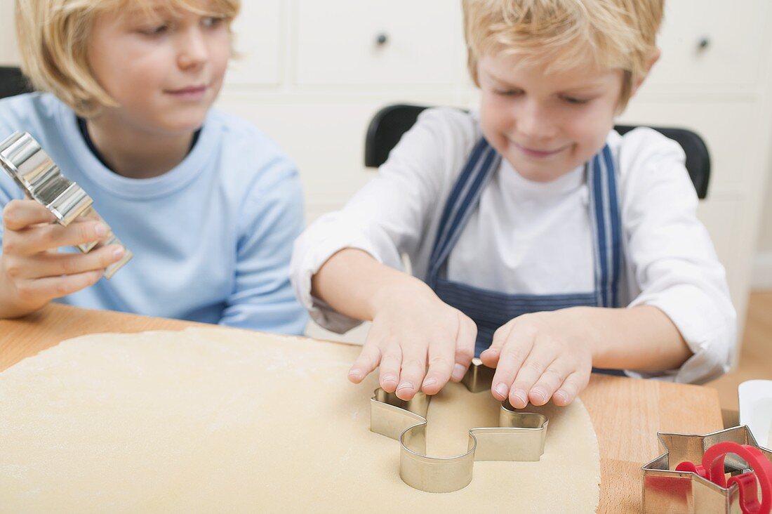 Two boys cutting out biscuits