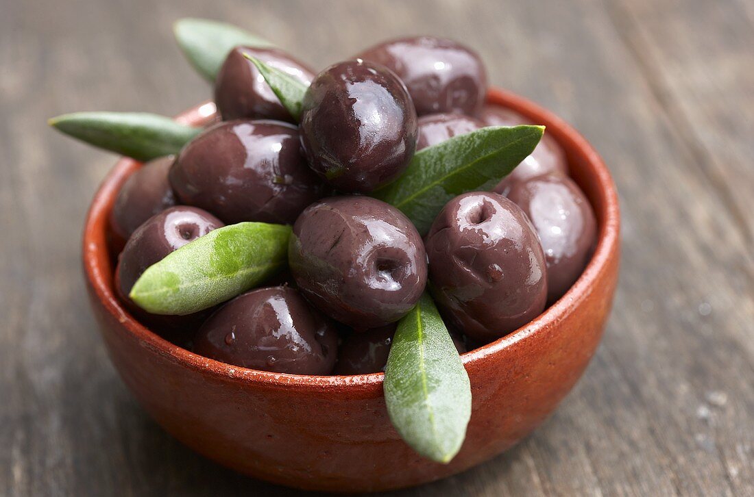 Black olives with leaves in bowl