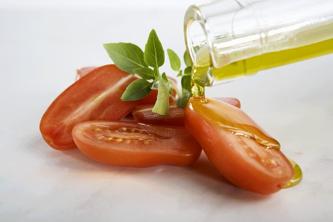 Pouring olive oil over tomatoes