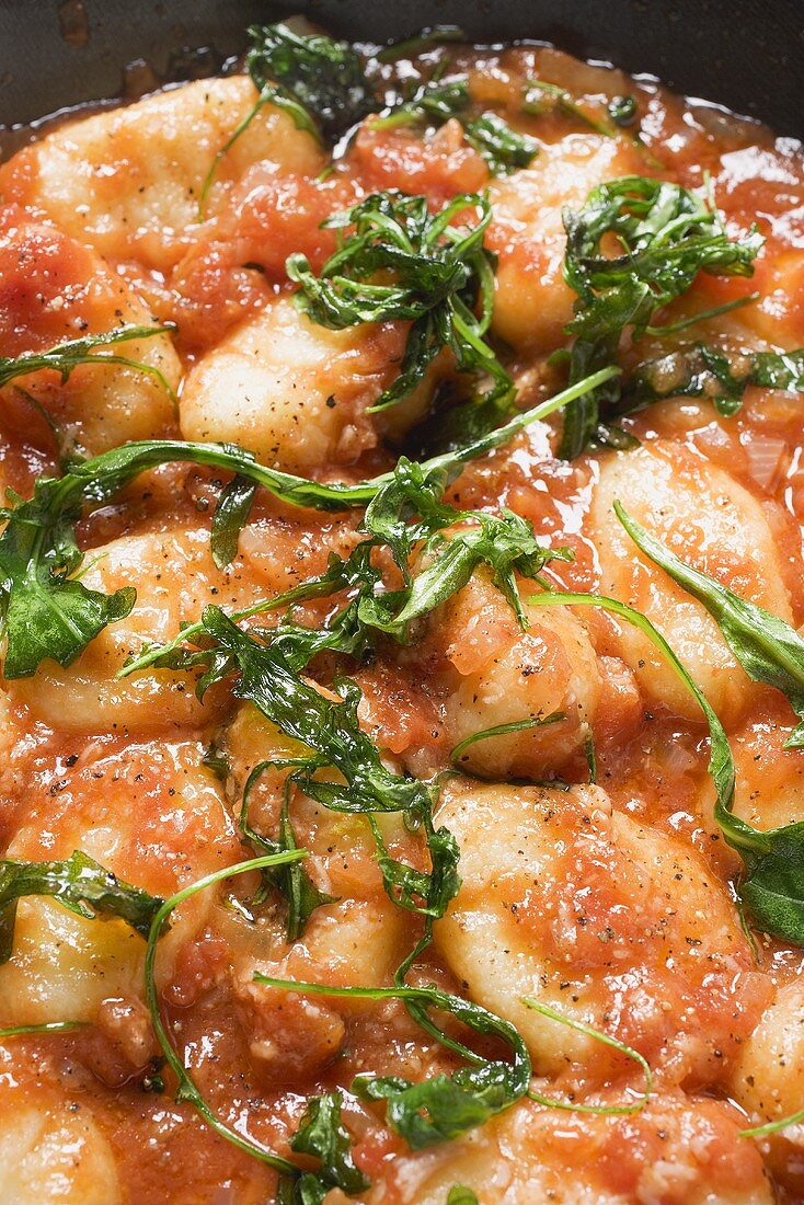 Gnocchi in tomato sauce with rocket (close-up)