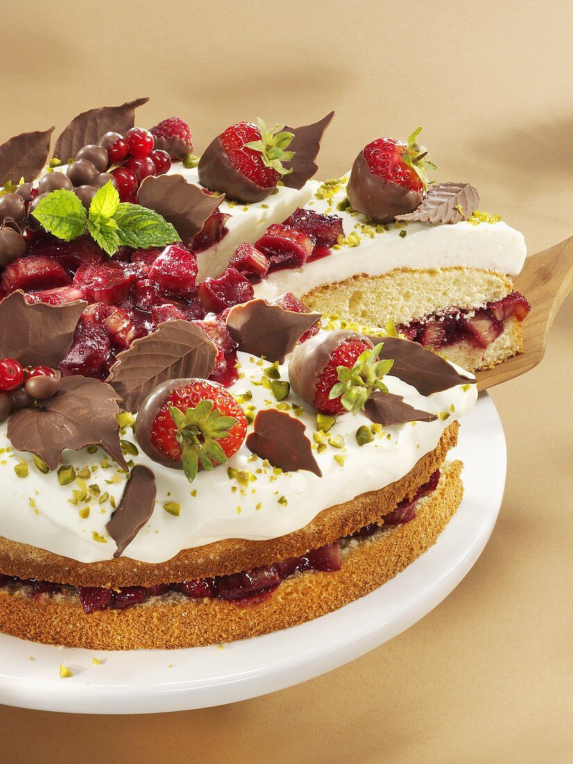 Rhubarb cake with strawberries, cream and chocolate leaves