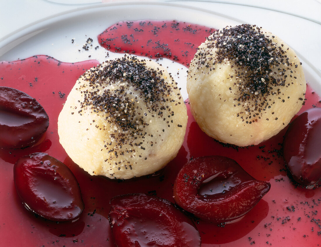 Plum compote and plum dumpling with marzipan filling on plate