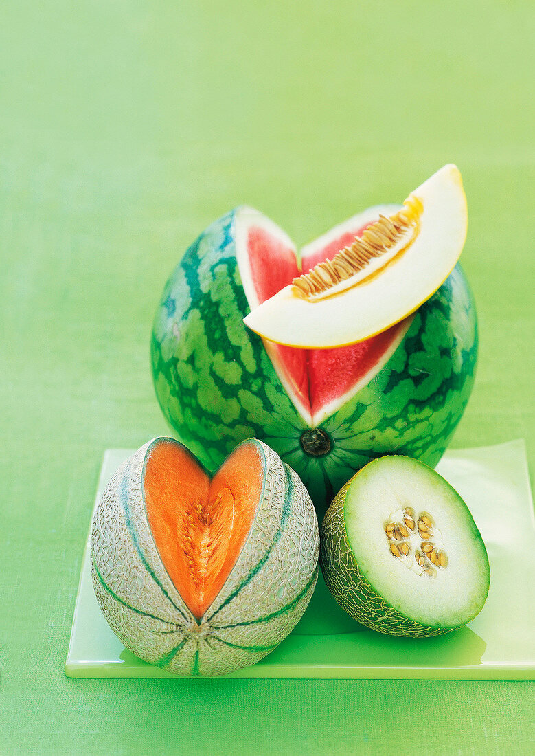 Honeydew melon, galia melon, watermelon and cantaloupe on chopping board