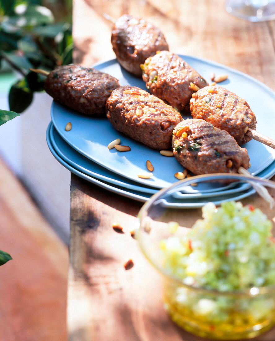 Koftas on skewers and melon salsa with pine nuts for a barbecue