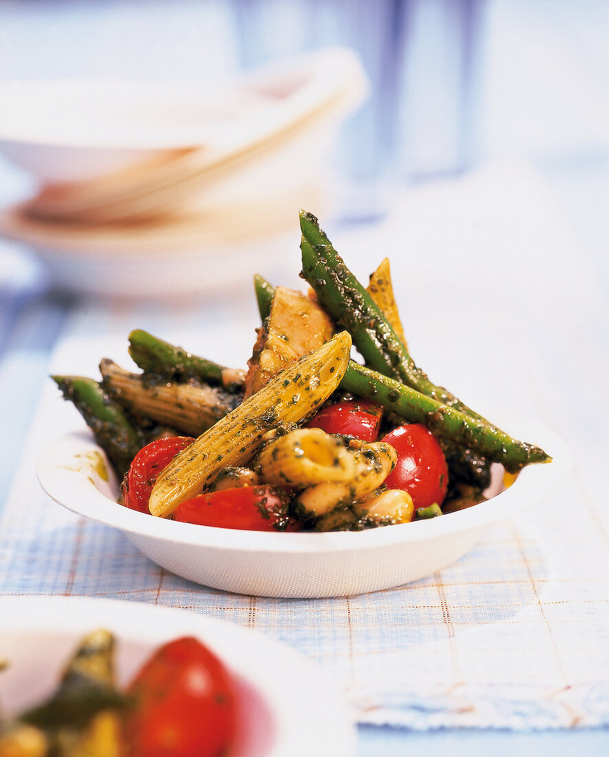 Pasta salad with beans and tomatoes in white bowl